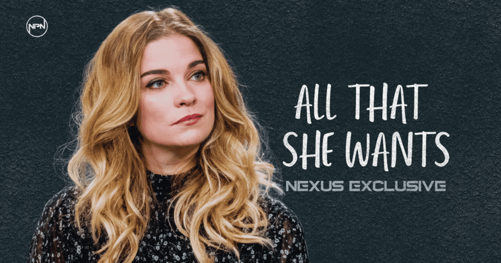 Annie Murphy against grayish blue background. The text reads All That She Wants Nexus Exclusive